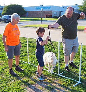 Leaders and 4-H'er with dog on agility course