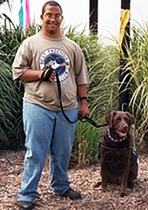 Young man and brown labrador retriever